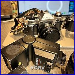 Vintage lot of 2 Canon AE-1 cameras (one Program) with lenses, a flash, manuals